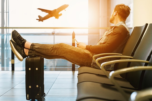 samotný muž v letištní hale smutně sleduje odlet letadla
